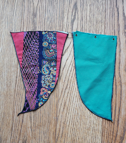 Seite A: zwei Fähnchen auf Boden mit je drei Ösen